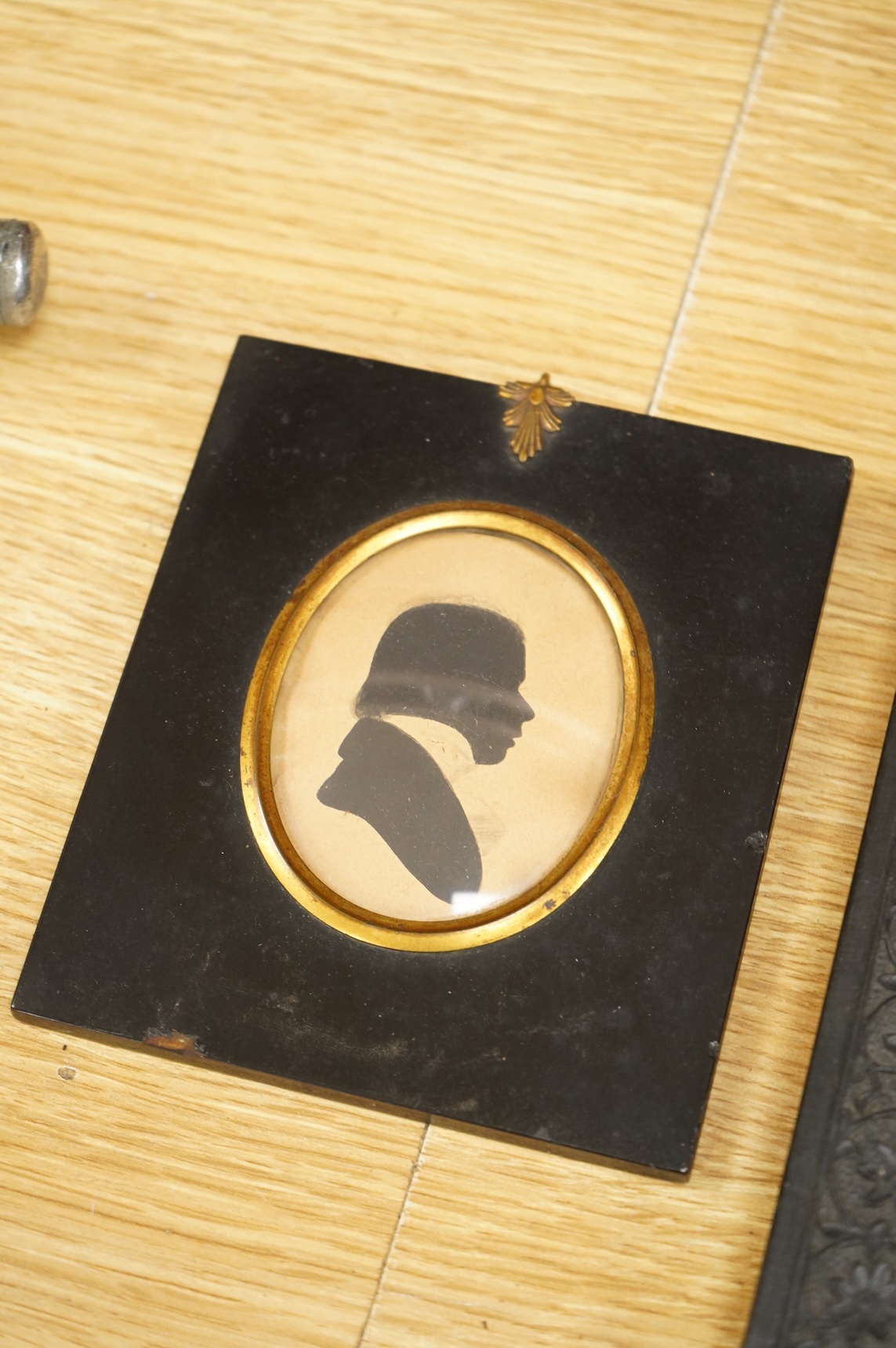 Early 19th century, English School, Cut paper silhouette portrait of a young man in academic robes and mortar board, together with two other silhouette portraits, with inscriptions verso, to include Reverend Lowry Guthri
